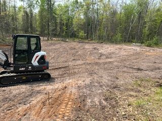 A bulldozer is sitting in the middle of a dirt field.