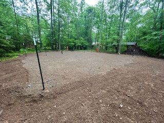 A large dirt field with trees in the background