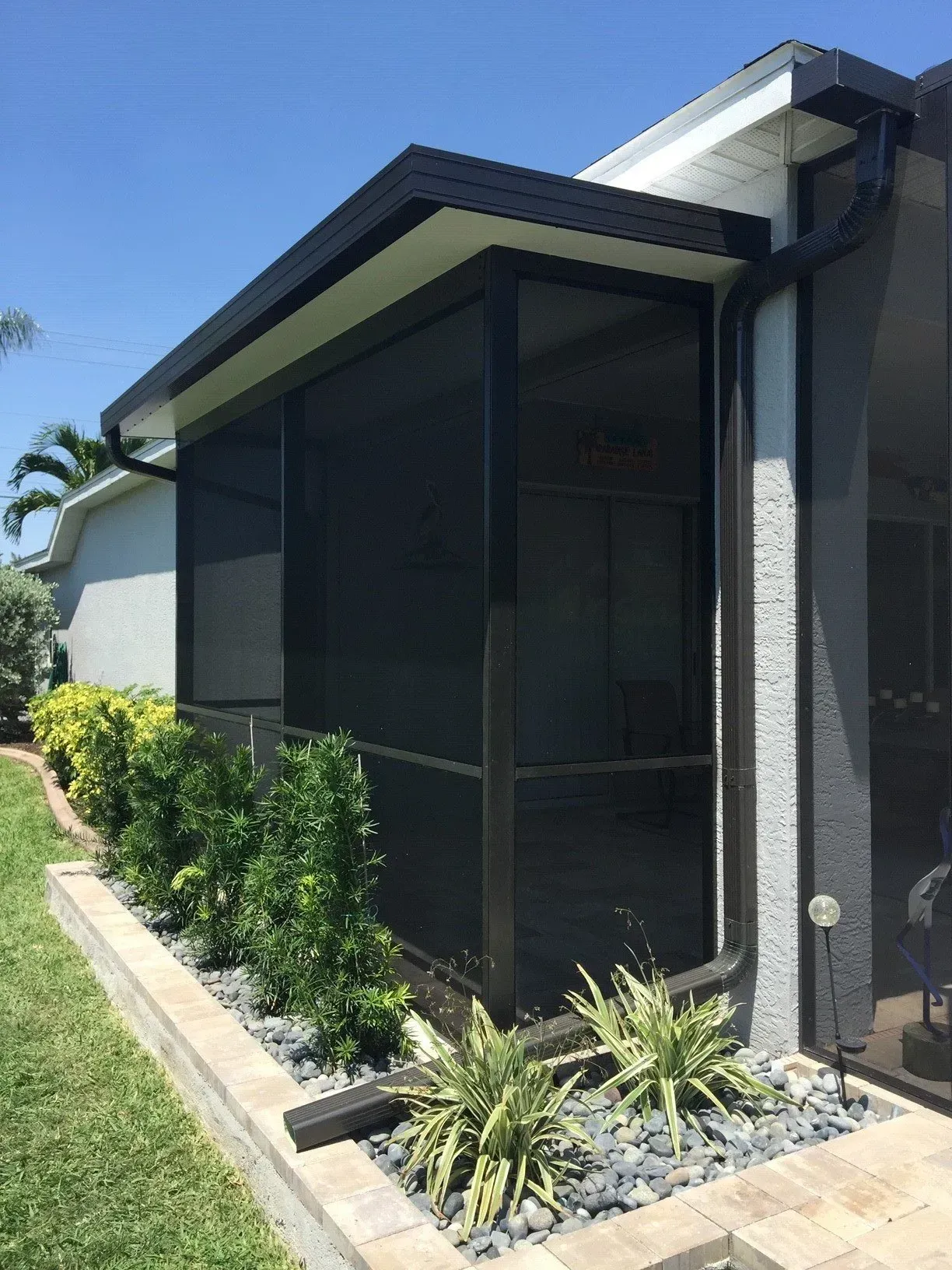 A house with a screened in porch on the side of it.