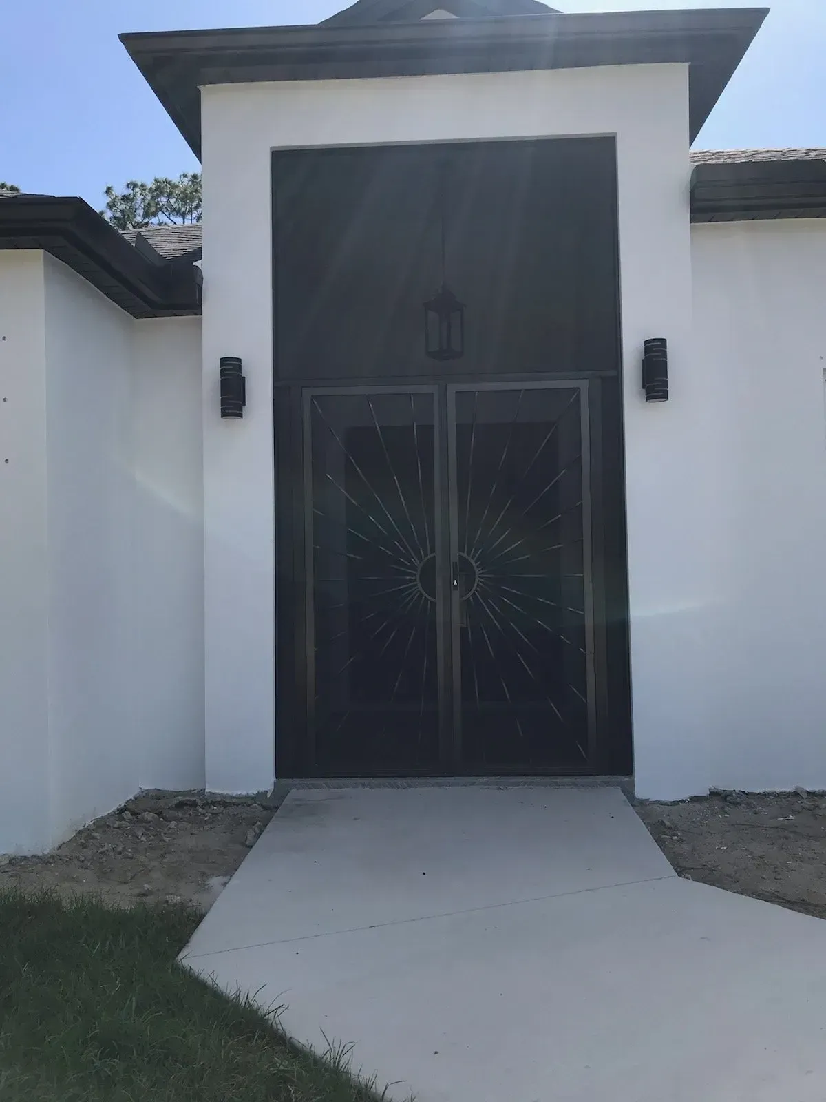 A white building with a black door and a walkway