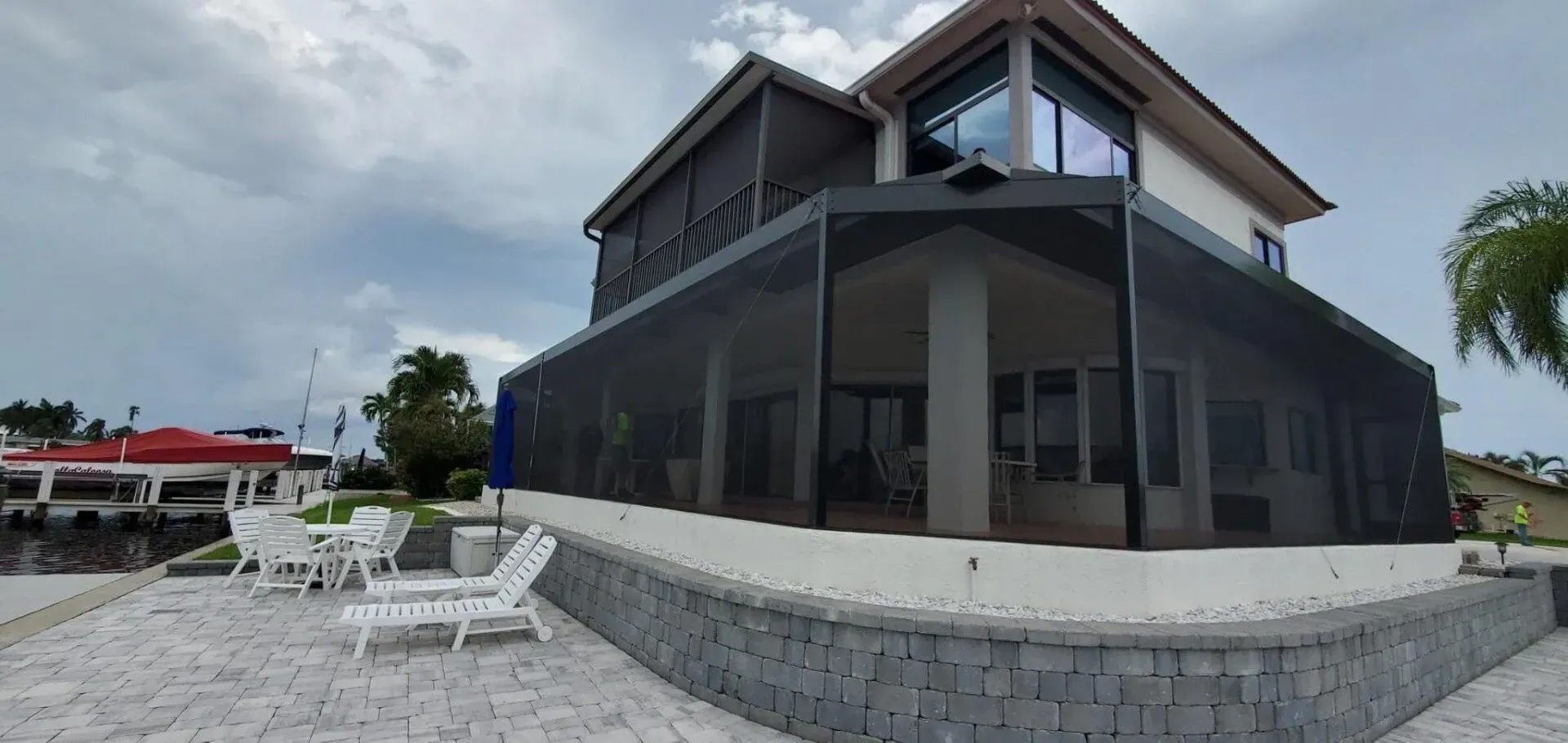 A large house with a screened in porch and patio chairs