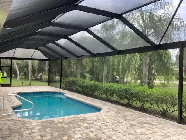 A screened in swimming pool with a clear roof