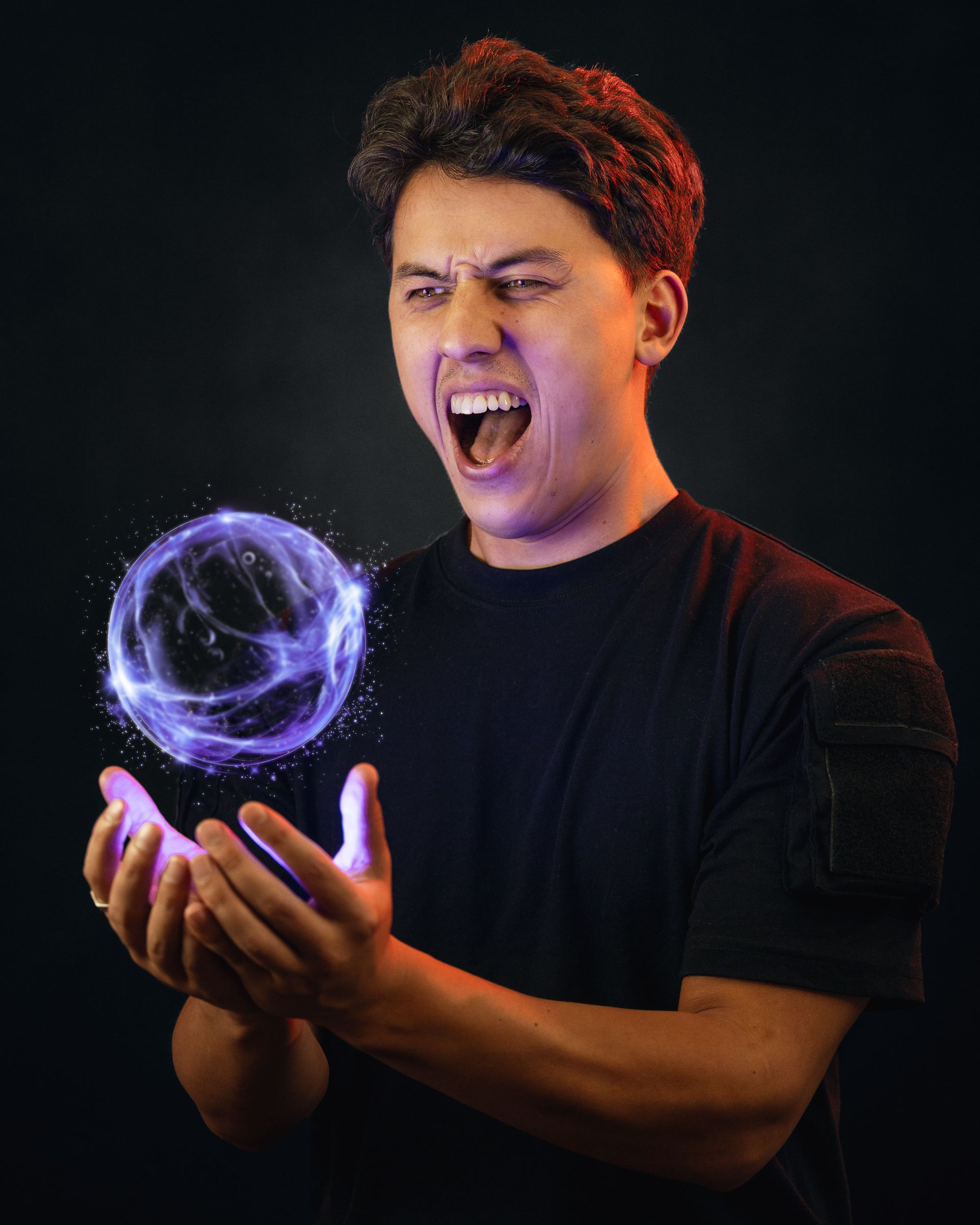 Man in black shirt with hands outstretched, creating a glowing purple energy ball, screaming against black background.