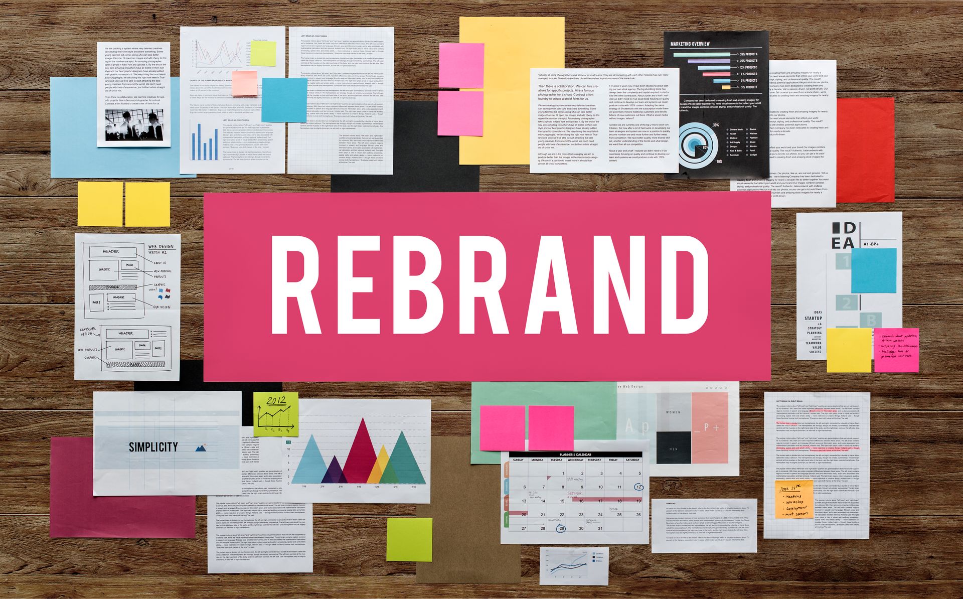 A wooden board with sticky notes and a sign that says rebrand
