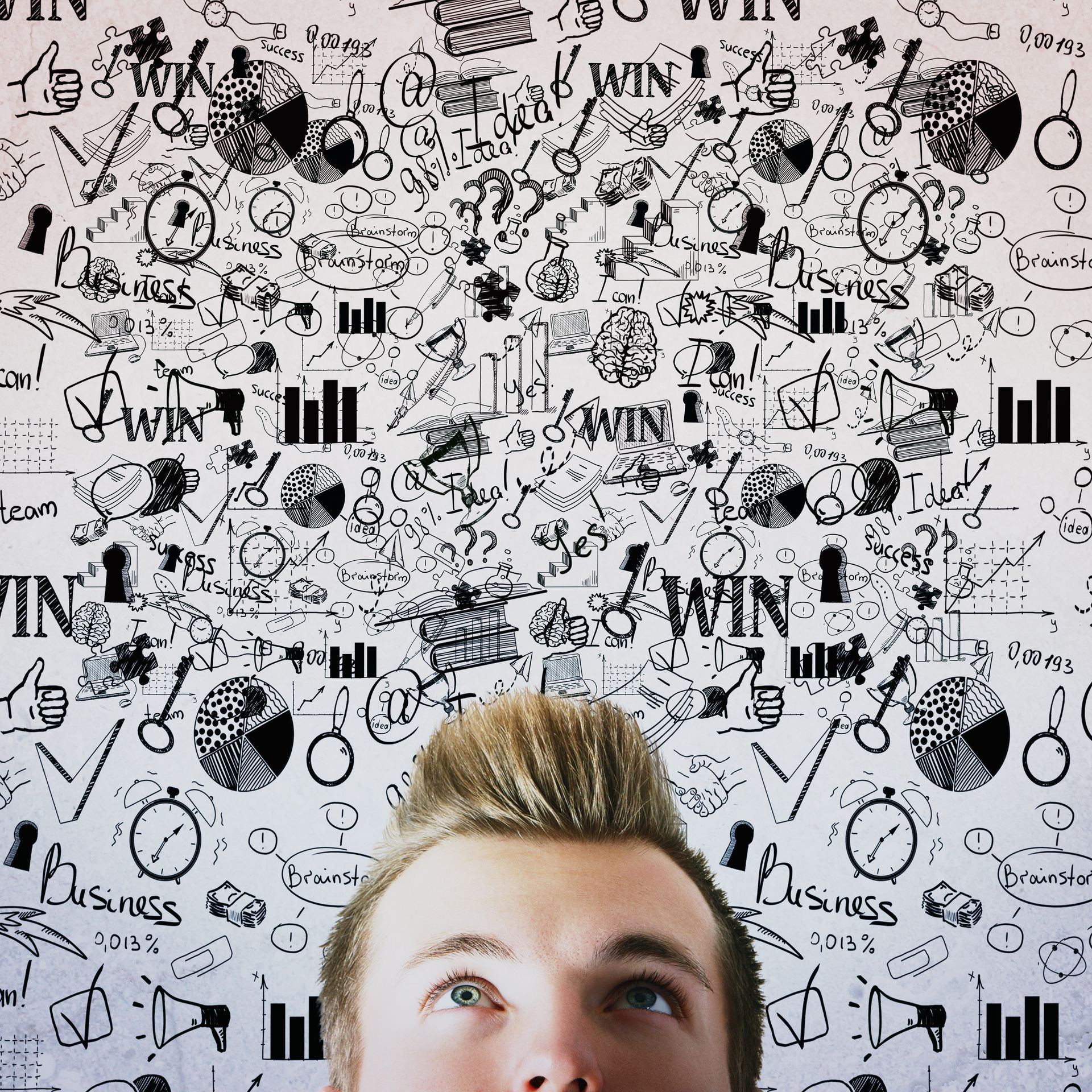A man is looking up at a wall with a lot of drawings on it.
