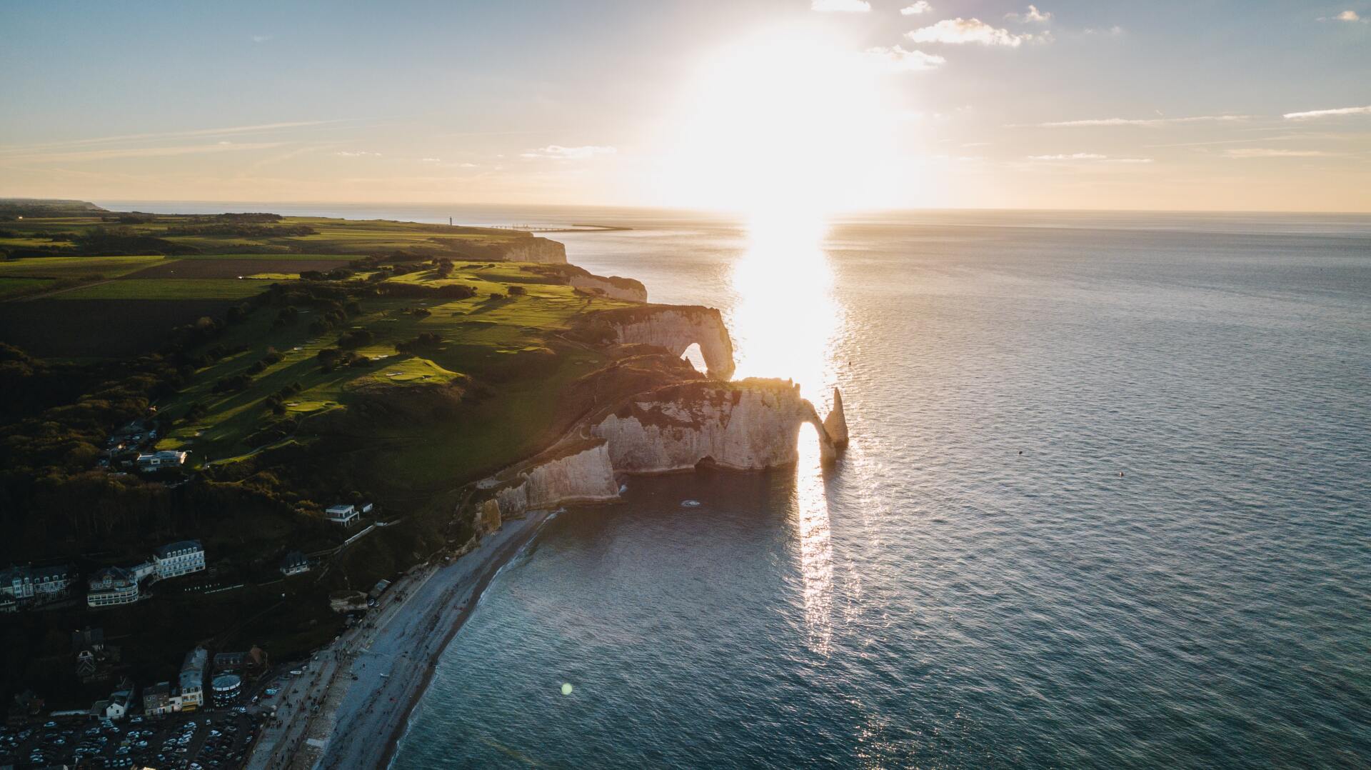 drone footage of a cliff overlooking the ocean at sunset.