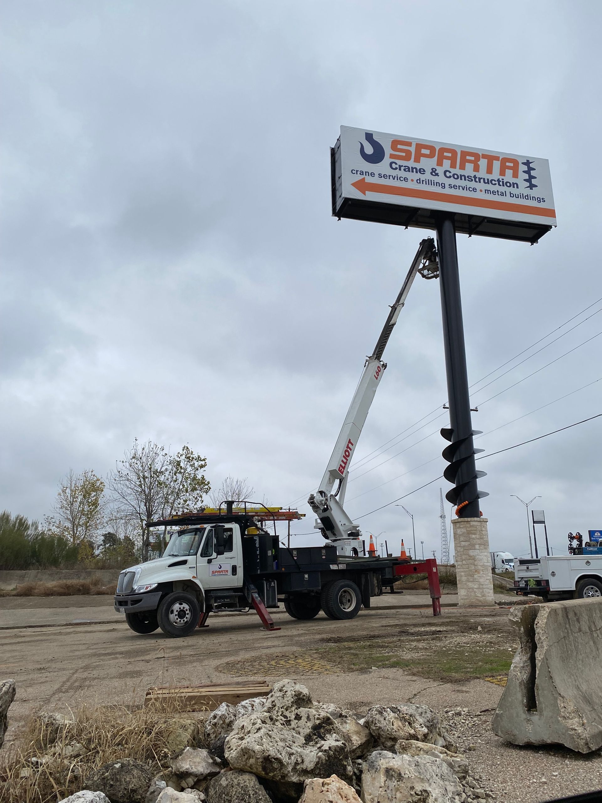 A truck is parked in front of a large billboard that says sparta.