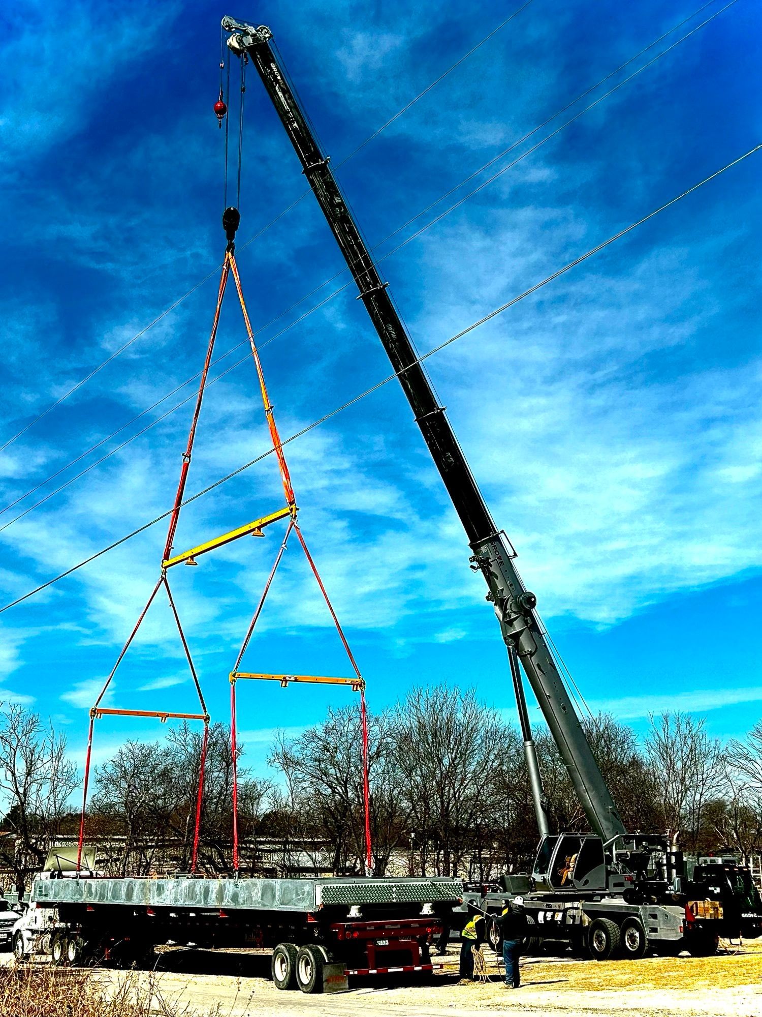 A large crane is lifting a large piece of metal