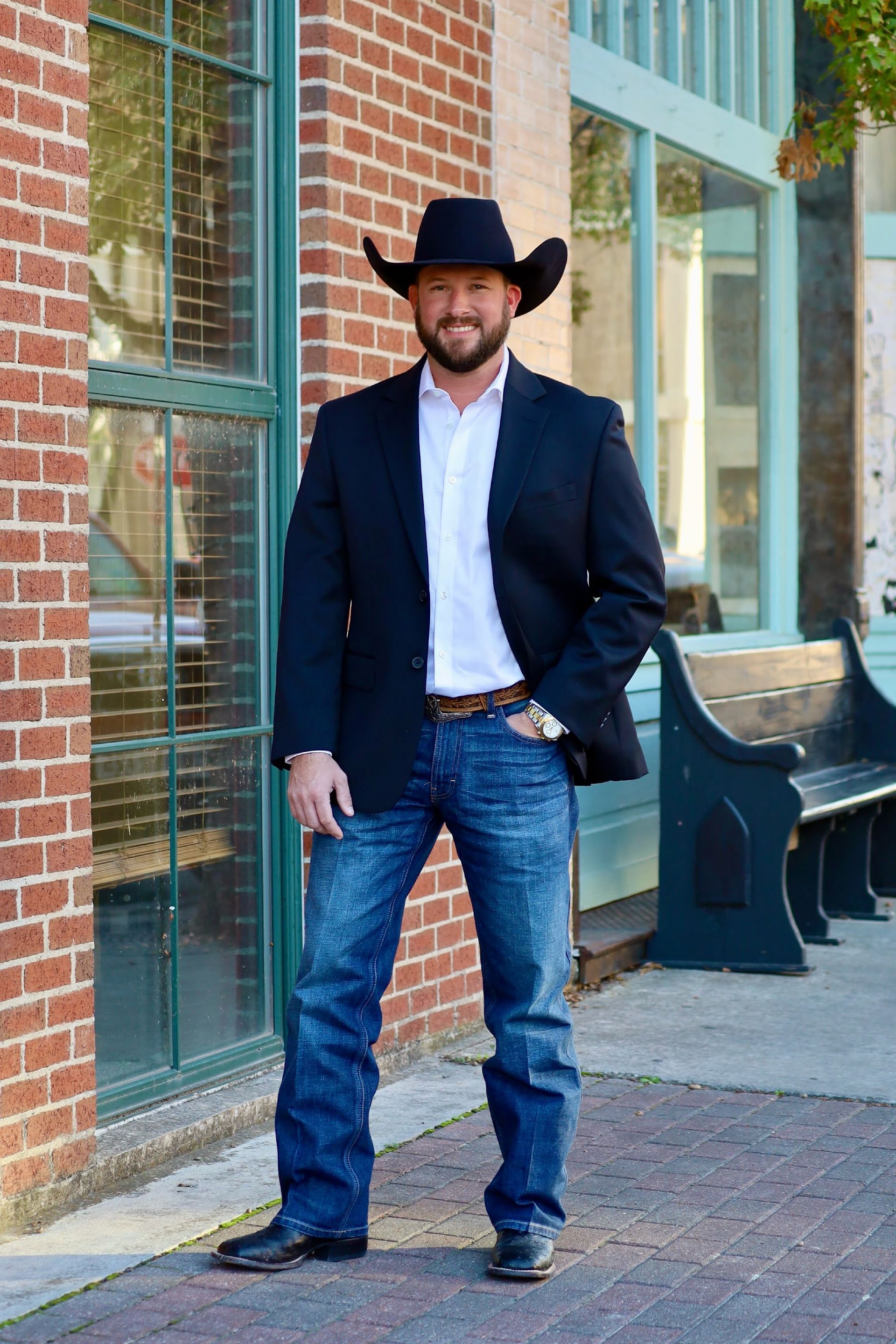 A man with a beard is wearing a suit and smiling for the camera.