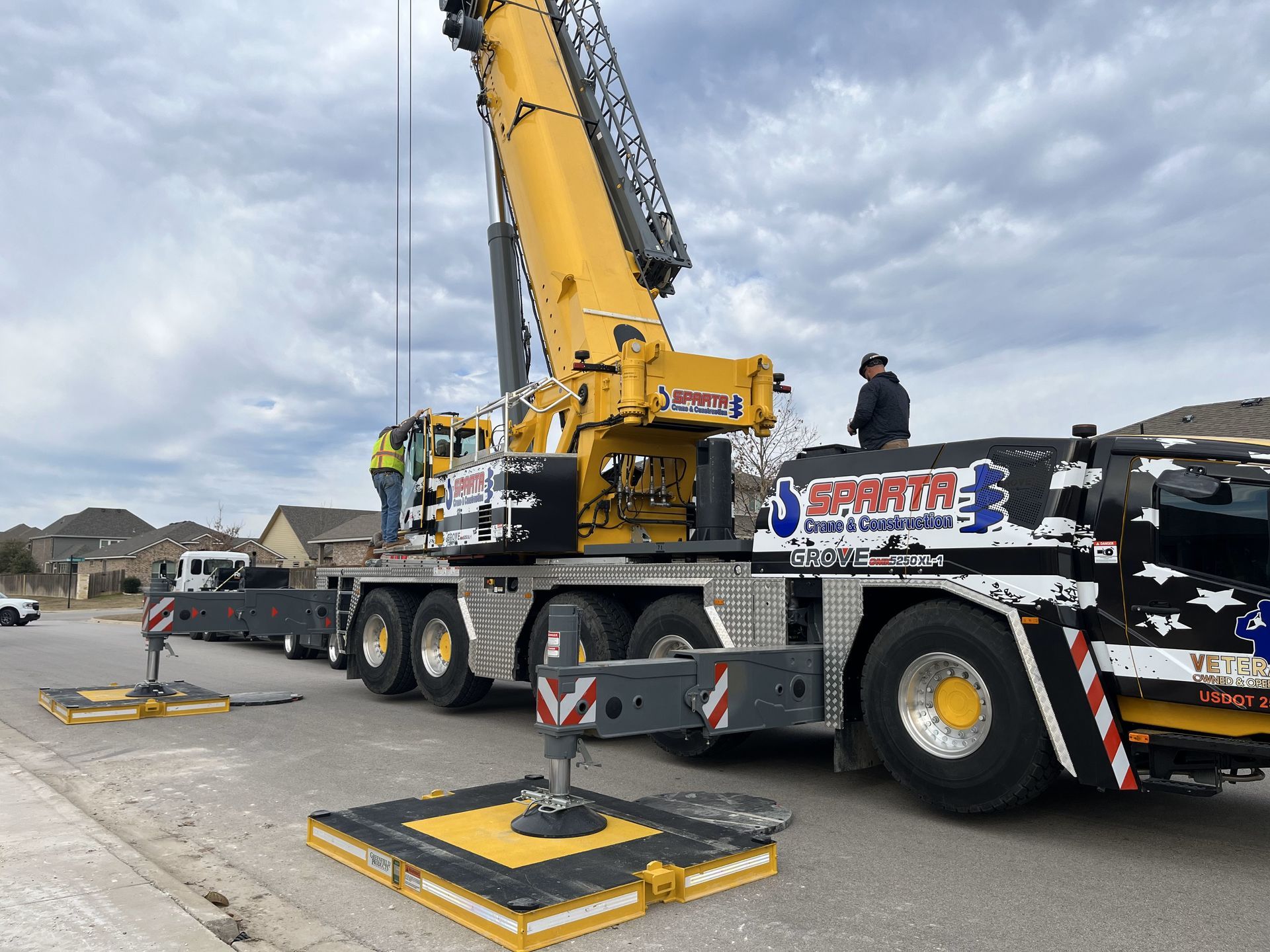 A large crane is sitting on top of a truck in a parking lot.