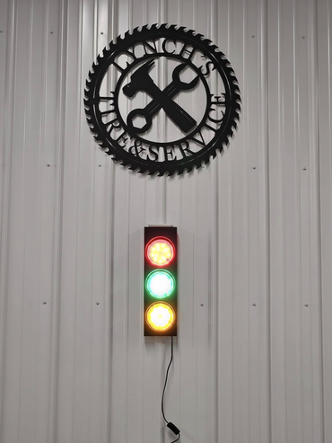 Black Lynch Garage Service sign above a traffic light with red, yellow, and green lights illuminated.