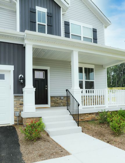 A white house with black shutters and a porch