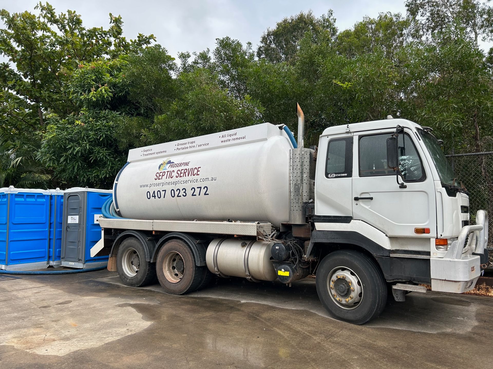 A White Truck is Parked in a Parking Lot Next to a Blue Box — Proserpine Septic Service In Cannonvale, QLD