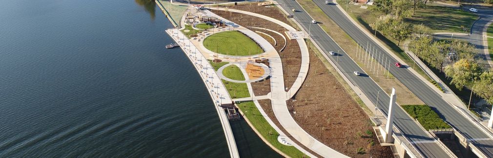 An aerial view of a park next to a body of water.