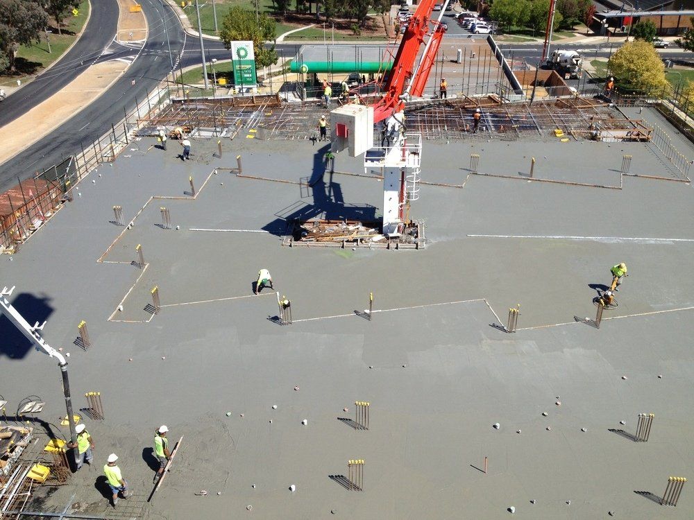 An aerial view of a construction site with workers and a crane