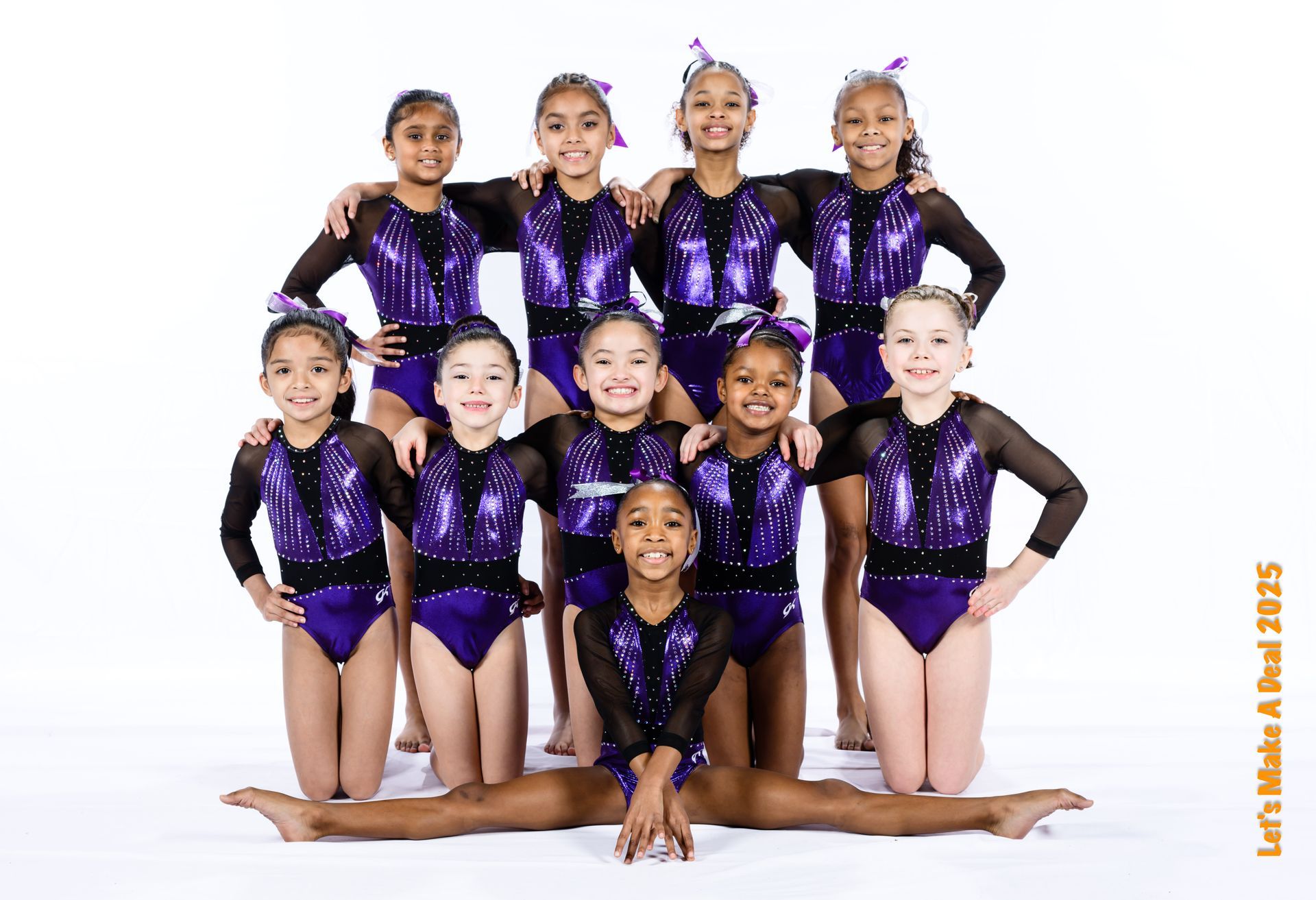 A group of young girls in purple leotards are posing for a picture.