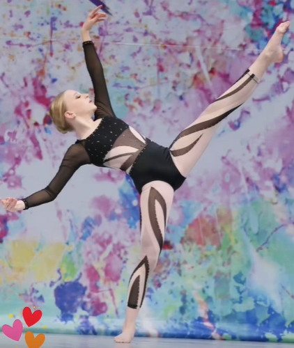 A woman is doing a split in front of a colorful background