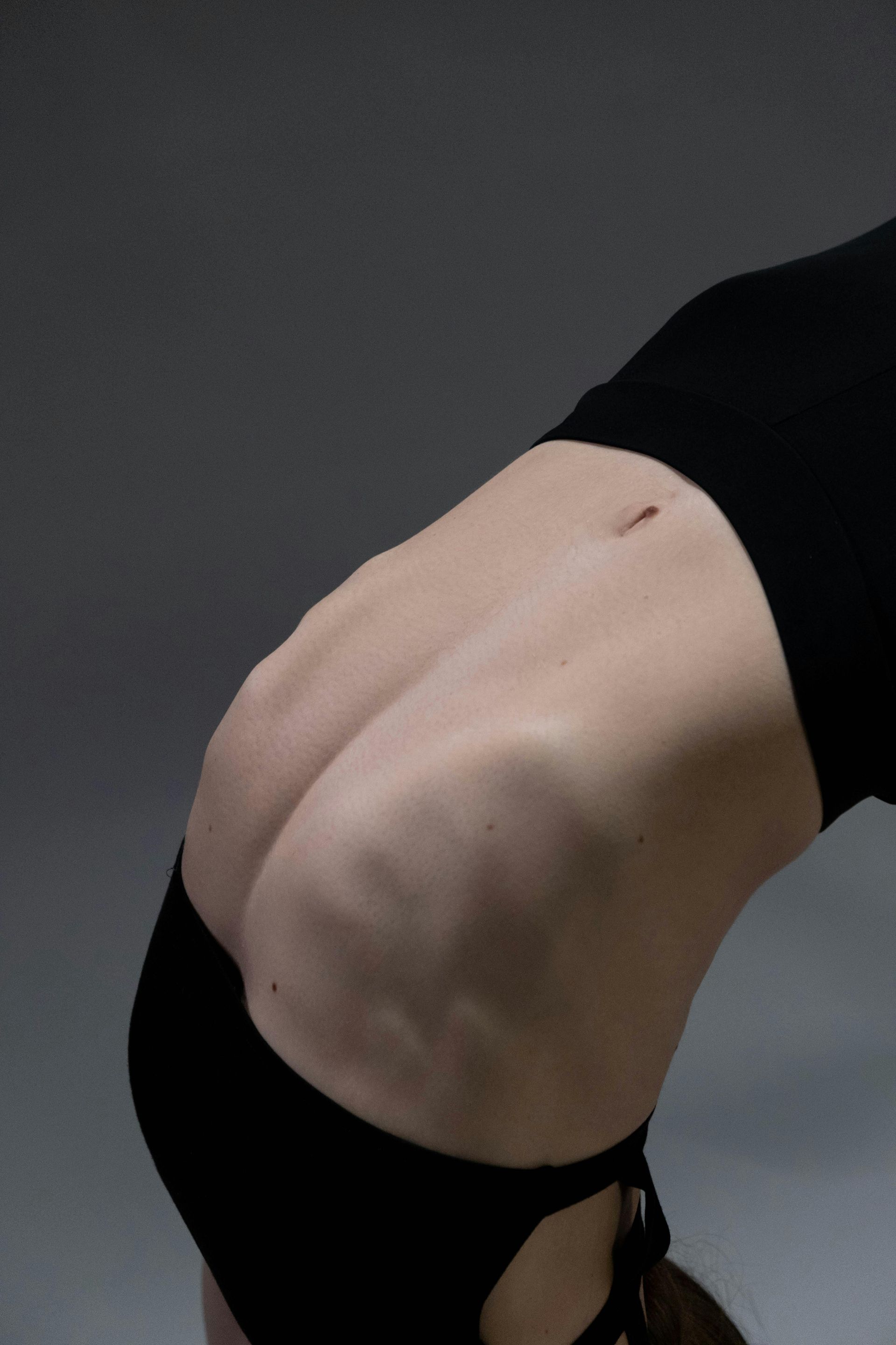 The back of a woman in a black bra is shown