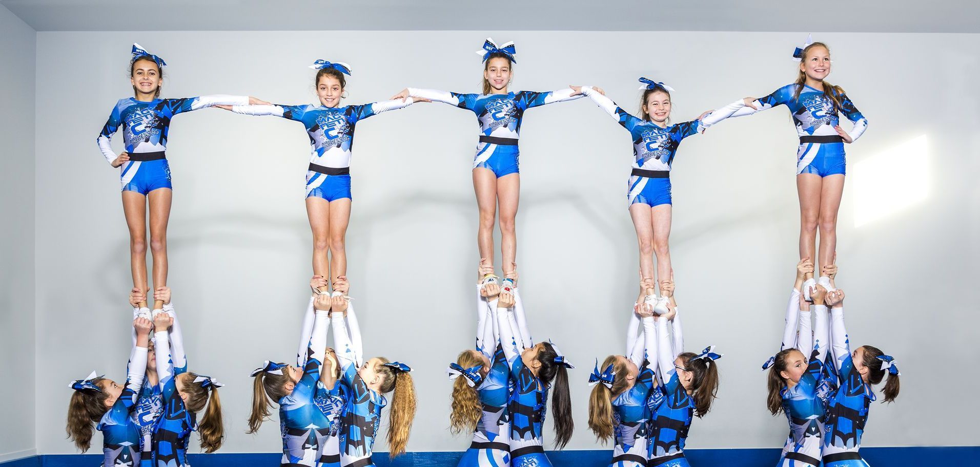 A group of cheerleaders are doing a pyramid formation.