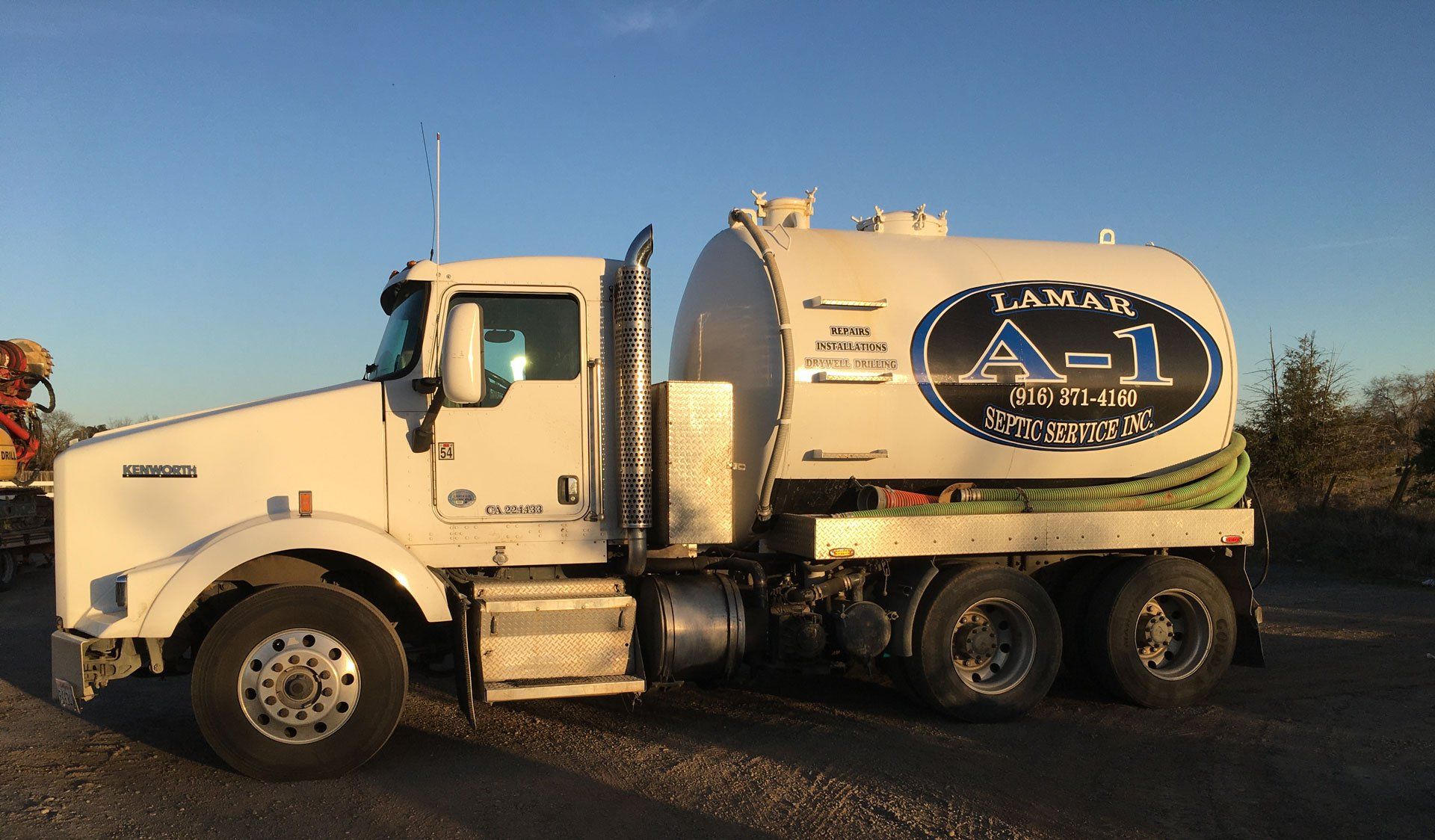 White septic truck with A-1 Septic Service logo on a rural road.