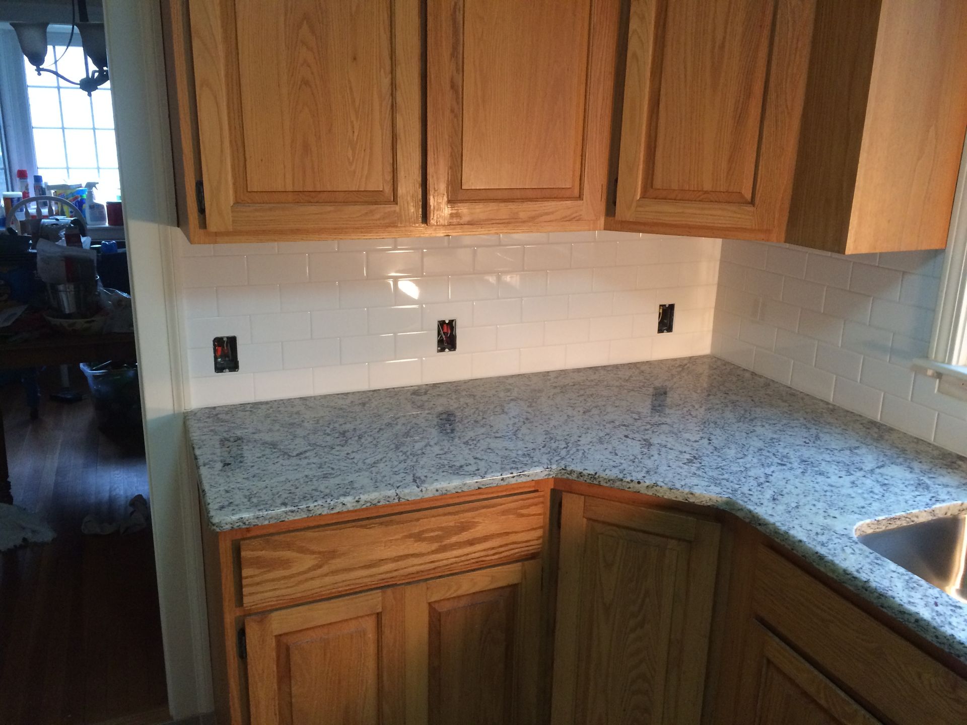 A kitchen with granite counter tops and wooden cabinets