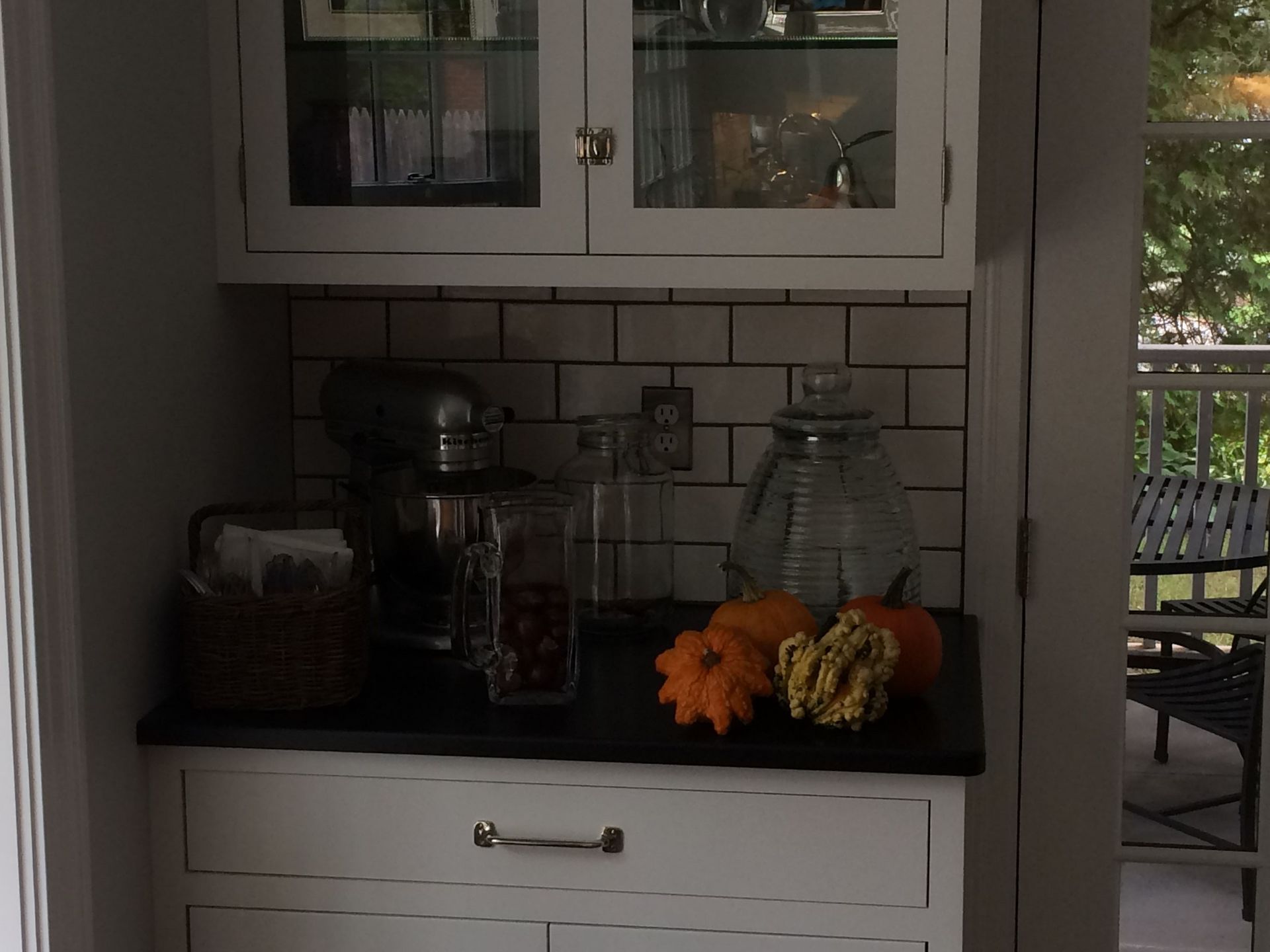 A kitchen counter with a blender and pumpkins on it