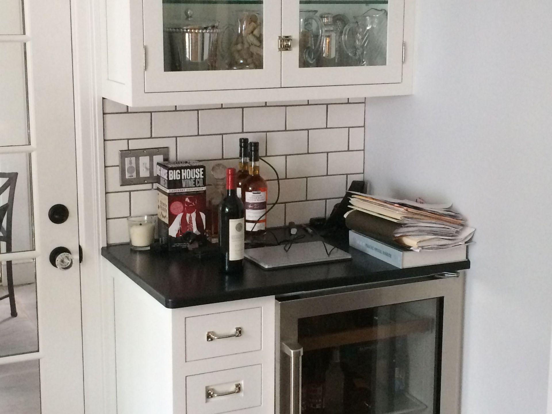 A bottle of wine sits on a counter in a kitchen