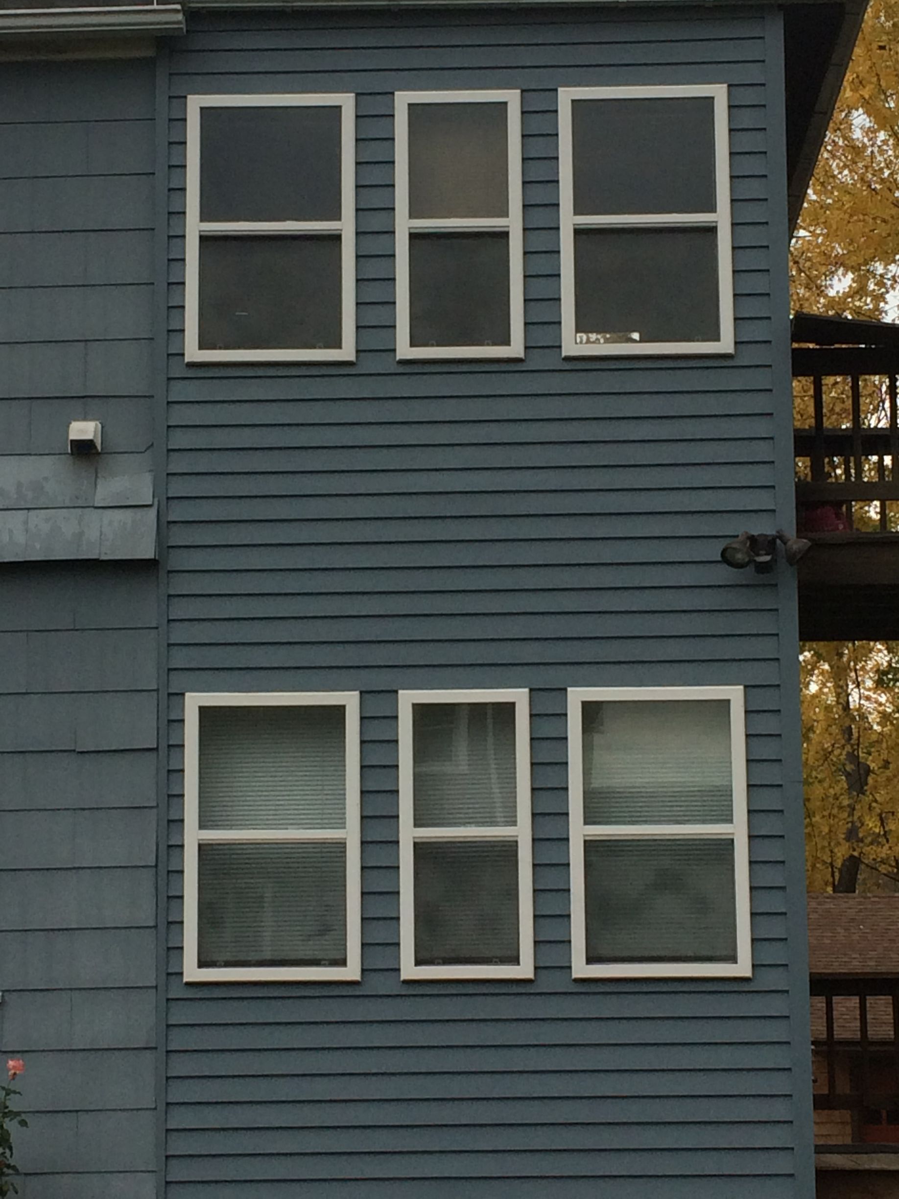 A blue building with three windows and a balcony