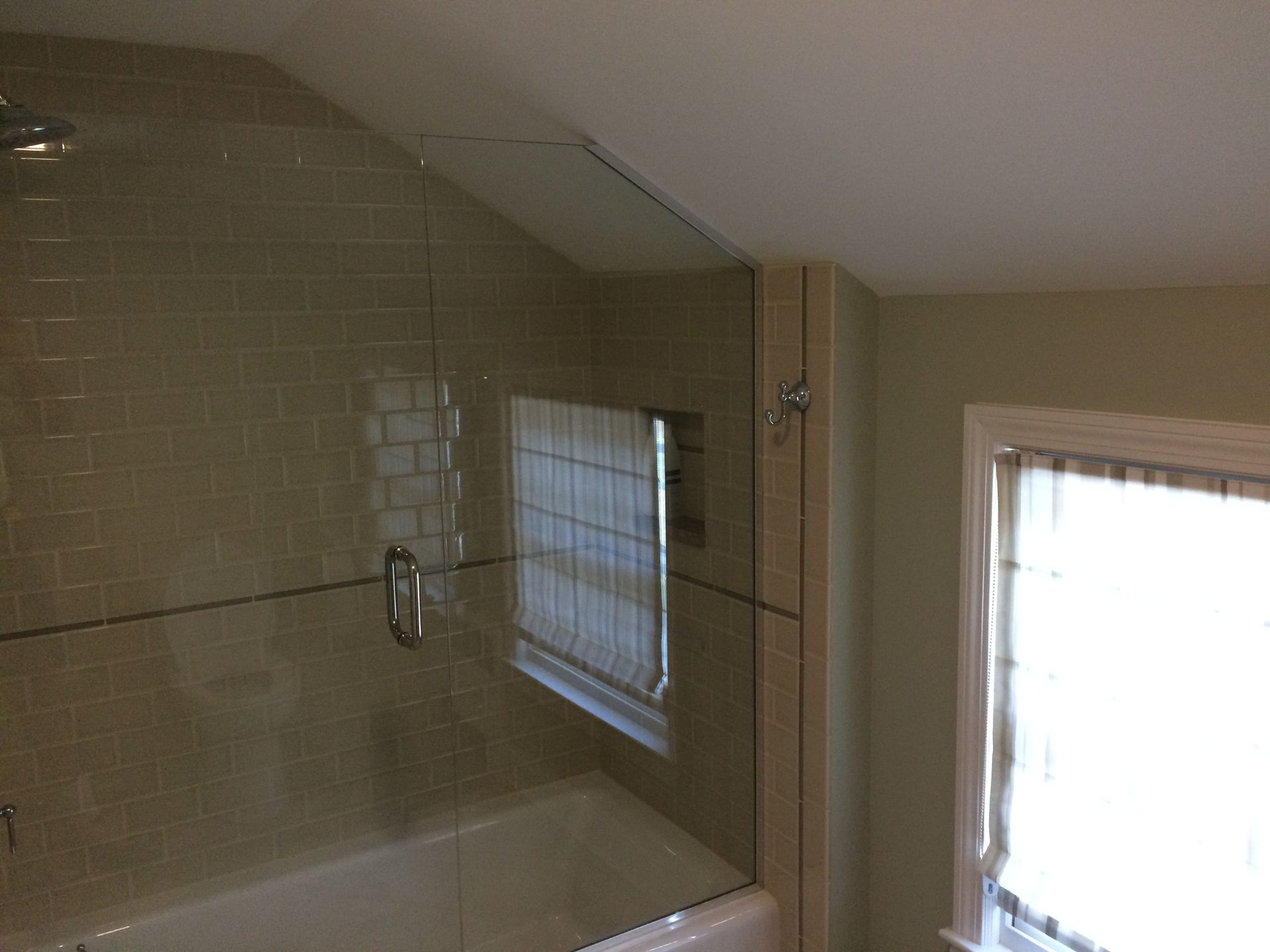 A bathroom with a bathtub and a shower with a glass door.