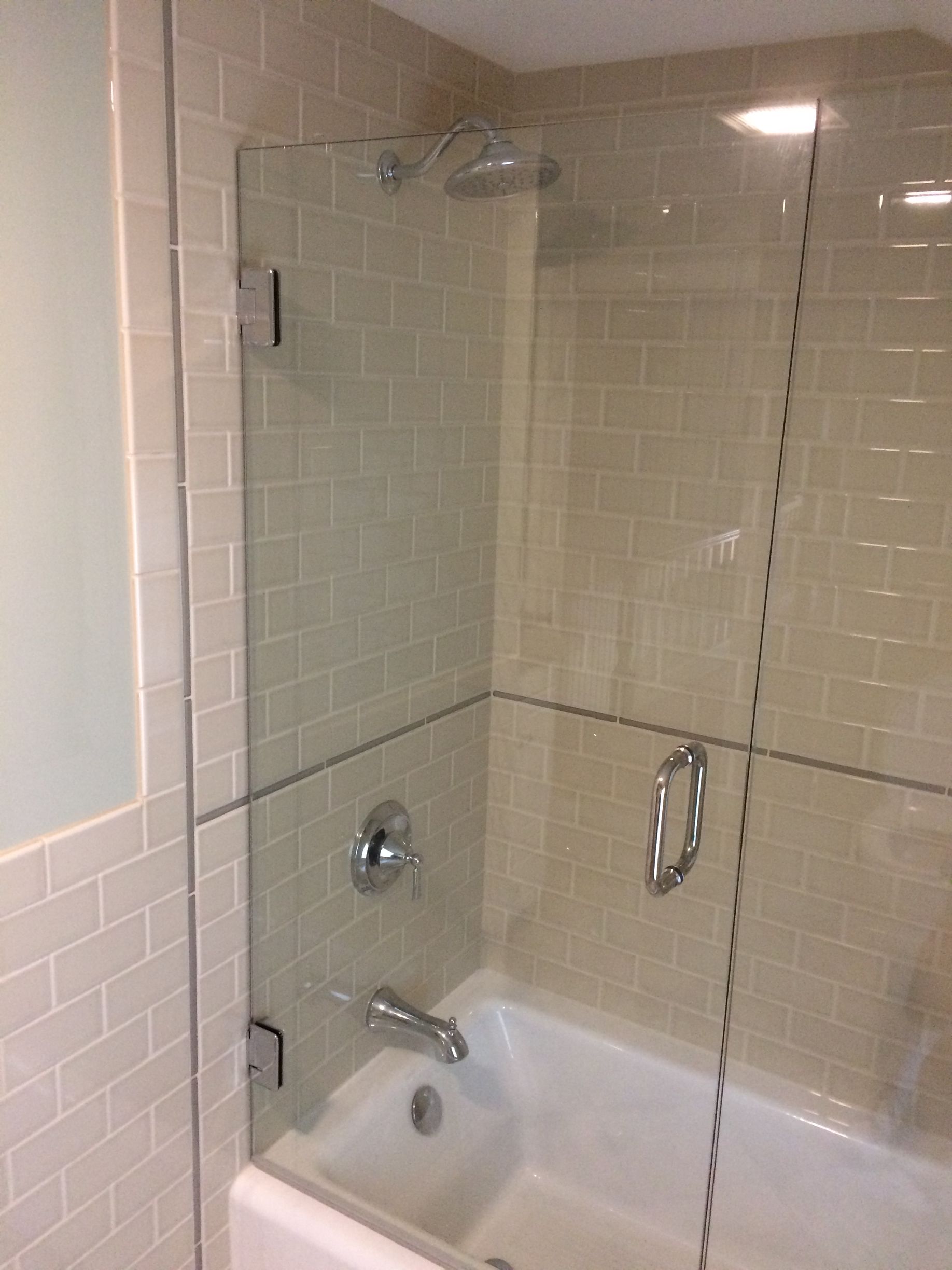 A bathroom with a bathtub and a glass shower door