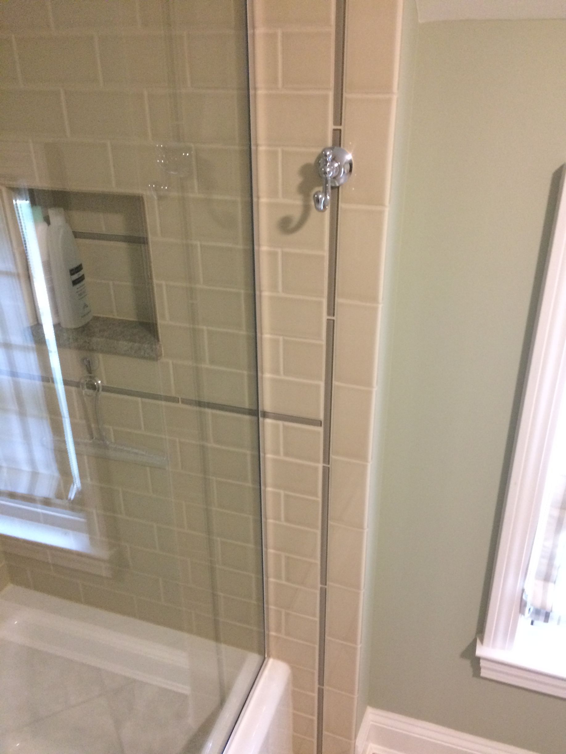 A bathroom with a shower stall and a window.
