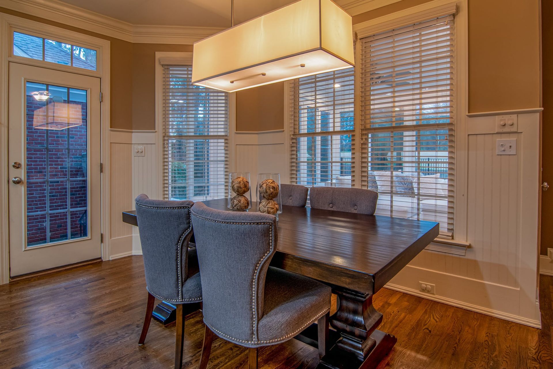 A dining room with a table and chairs and a chandelier hanging from the ceiling.