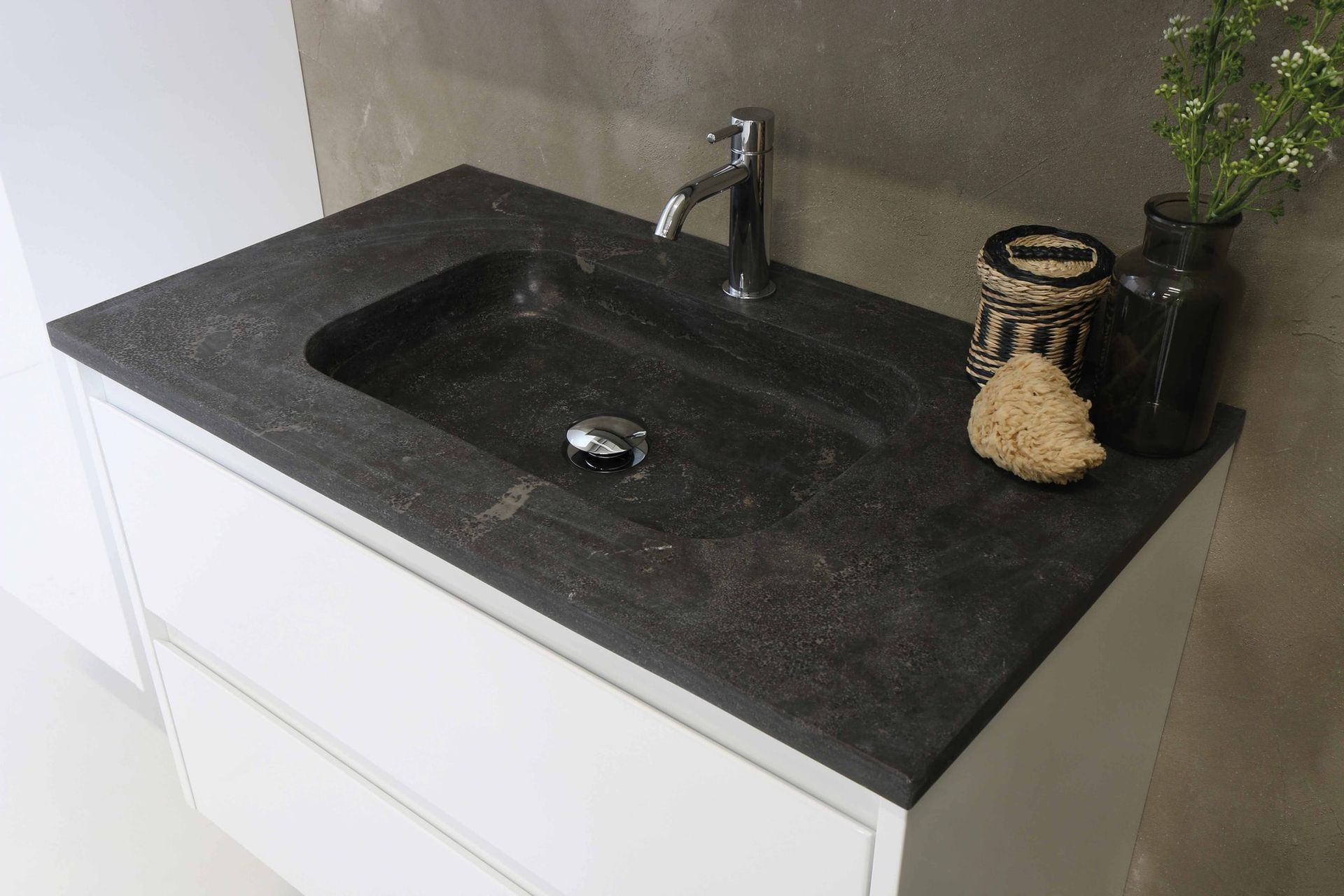 A bathroom sink with a black counter top and a faucet