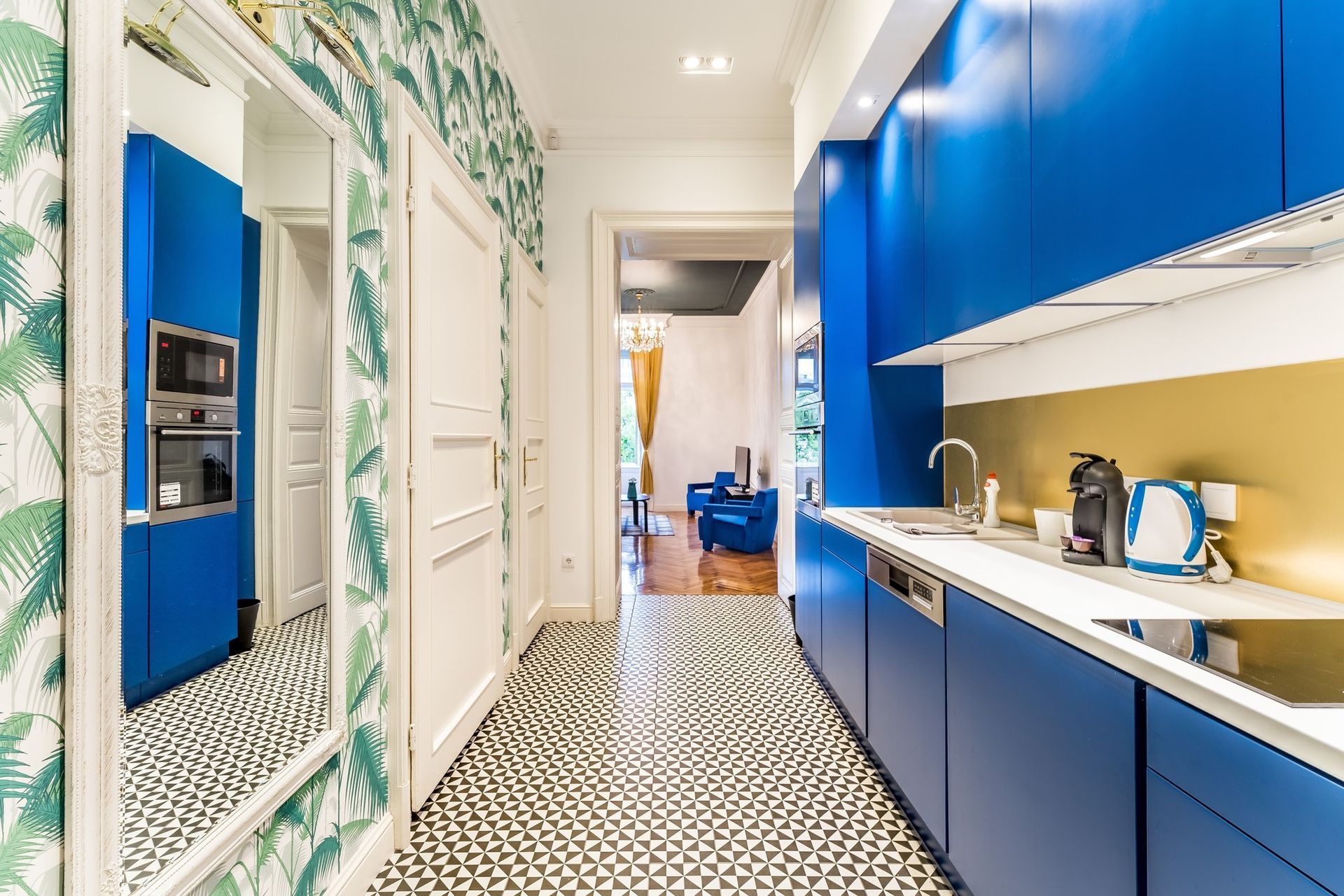 A kitchen with blue cabinets and a mirror on the wall.