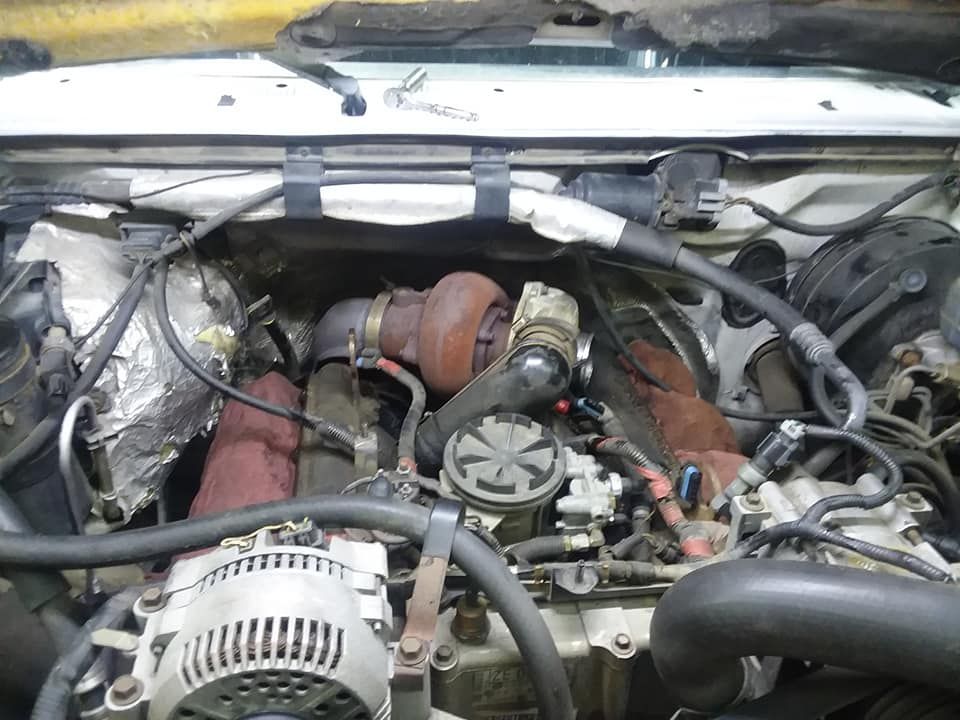 Diesel engine with turbocharger installed in an engine bay.