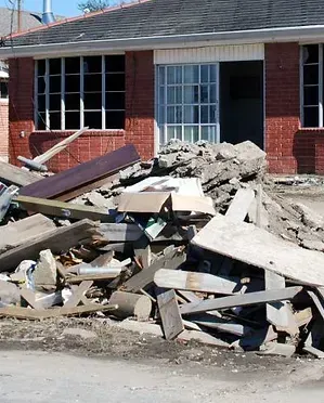 A pile of rubble in front of a brick house