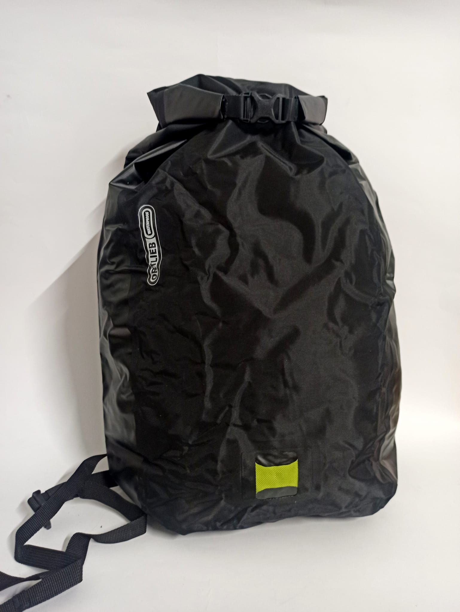 Zaino impermeabile nero con parte superiore arrotolata e chiusura con fibbia, su sfondo bianco.