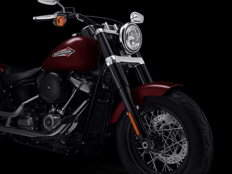 A red harley davidson motorcycle is parked on a black background.