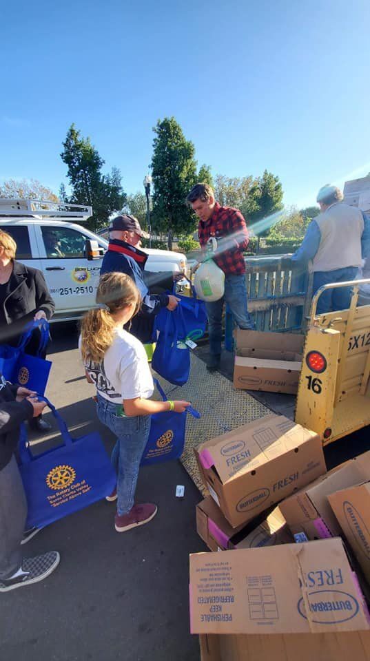 A group of people are standing around a pile of boxes.