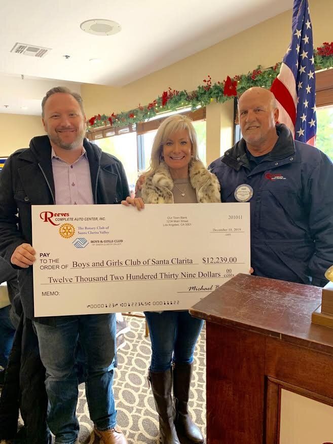 A group of people standing next to each other holding a large check.