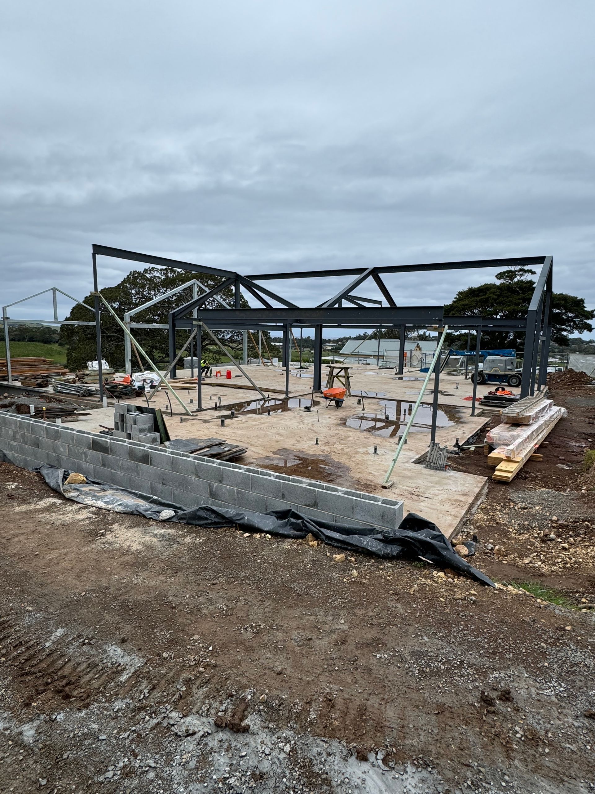 A large metal structure is being built in the middle of a dirt field.