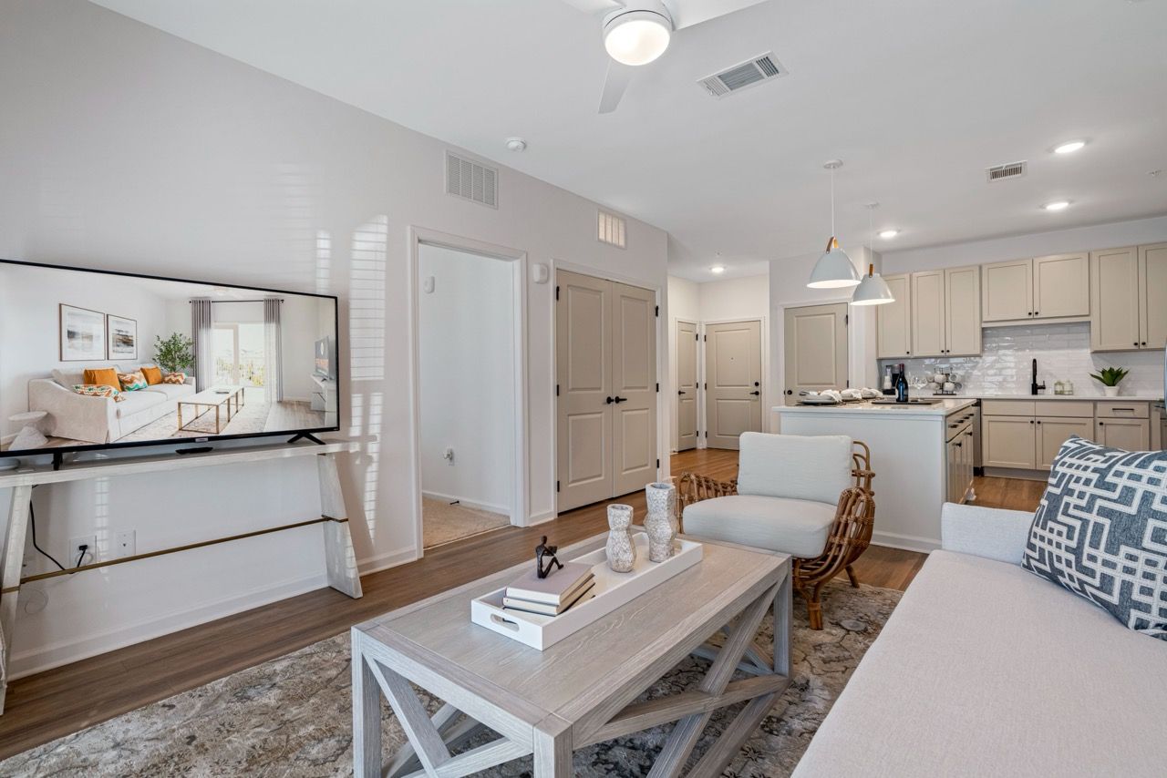 Open living room with TV, sofa, coffee table, and visible modern kitchen.
