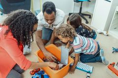 A family is playing with toys on the floor.