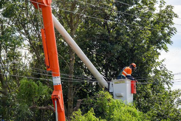 A man in a bucket is working on a power line.