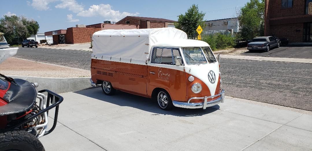 A volkswagen van is parked on the side of the road next to a atv.