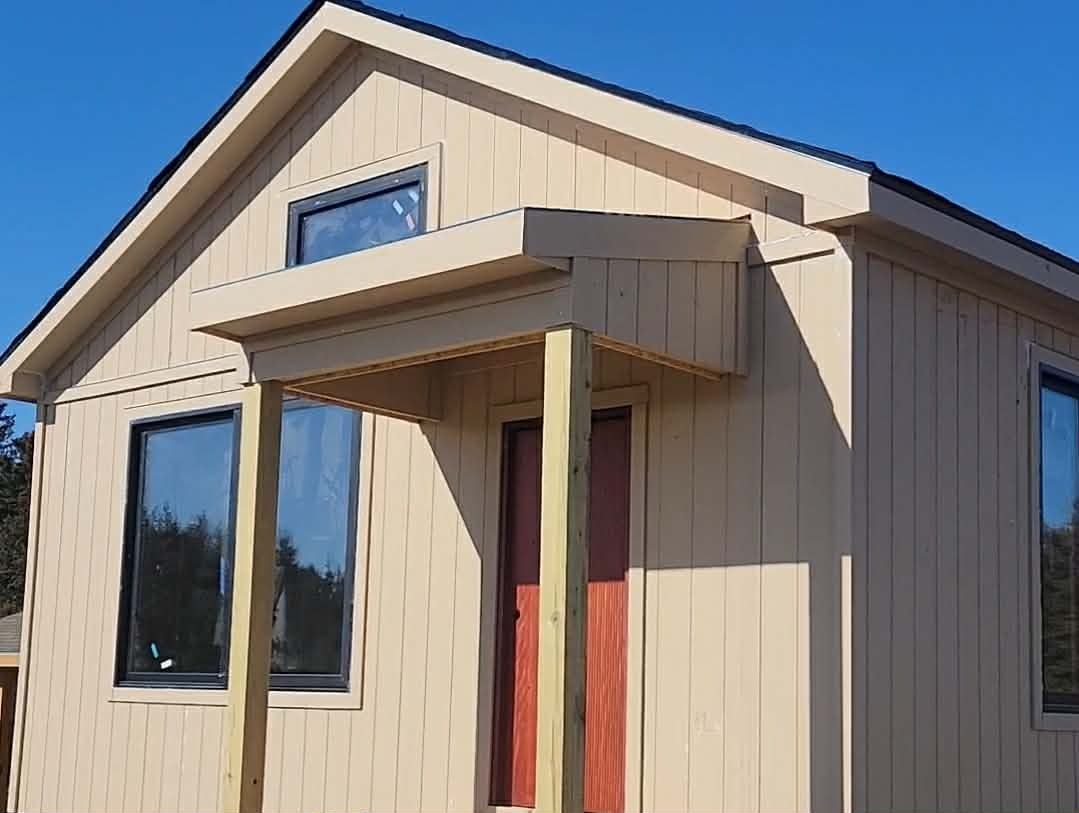 Kansas City skyline at dusk with lit buildings and open field in foreground.