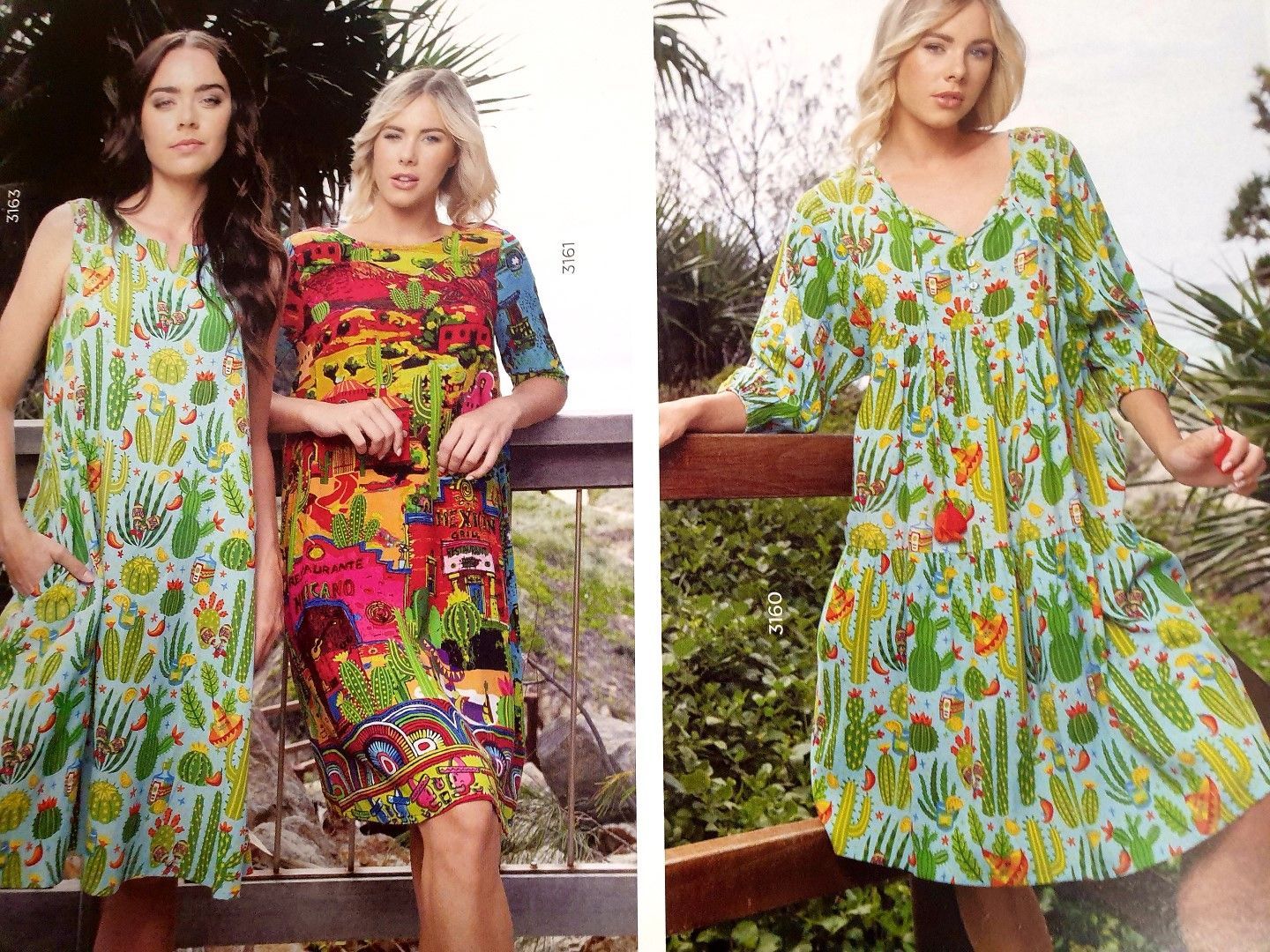 Three women in patterned summer dresses, one with cactus print, posing outdoors.