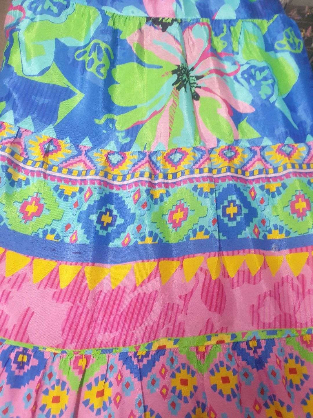 Colorful patterned tiered skirt with blue, pink, green, and yellow geometric designs.