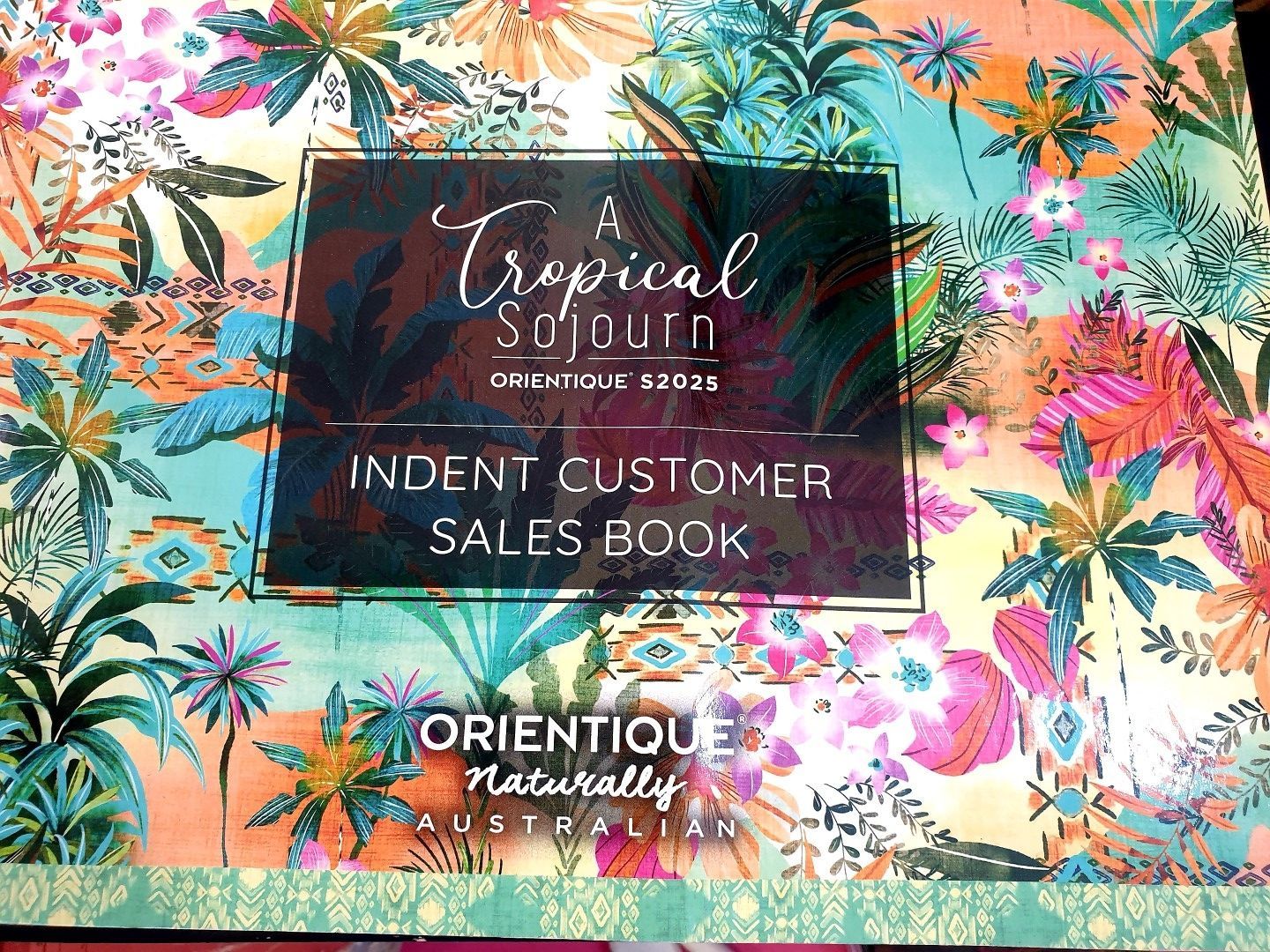 Cover of a sales book with a tropical design. The book is for Orientique products.