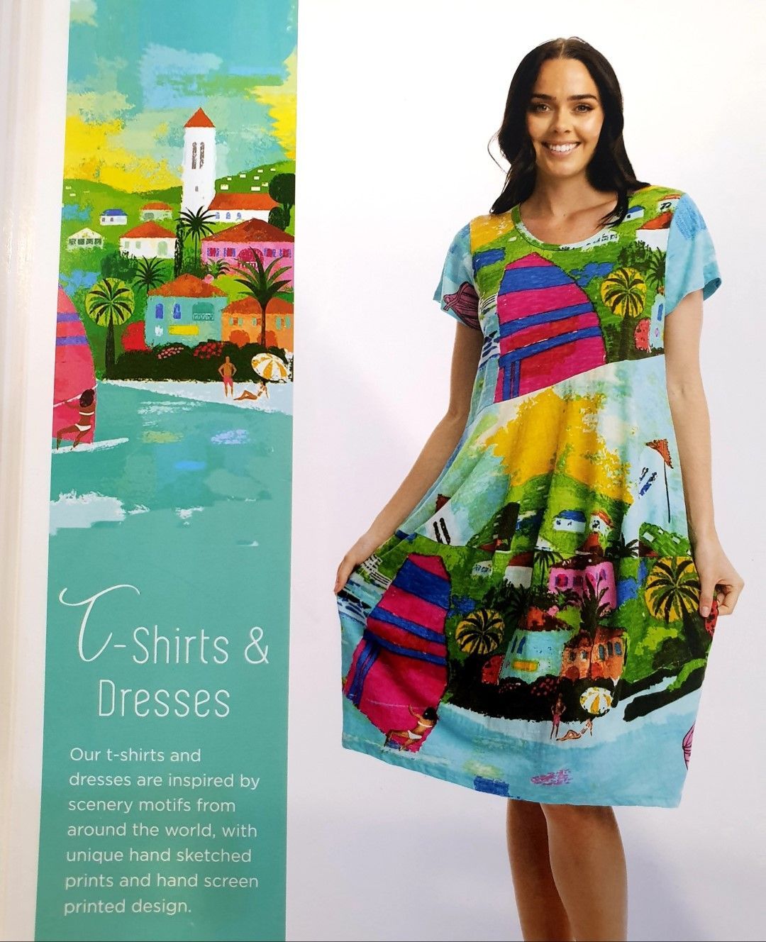 Woman wearing a colorful tropical print dress, standing in front of an advertisement for T-shirts and dresses.